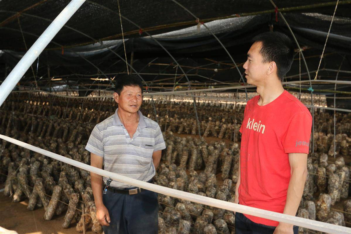 2010年，刚刚创业时的罗圆（右一）在和农户交谈。受访者供图