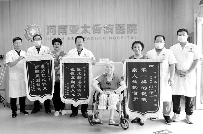     王瑞（左四）接受患者赠送的锦旗。    通讯员 马景 摄