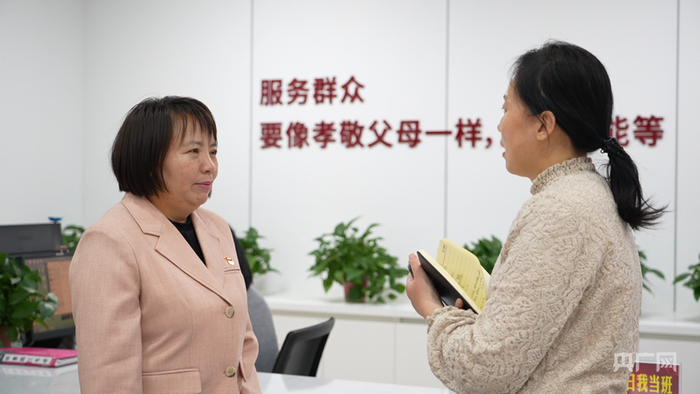 林则银（左）和同事在交流工作（央广网记者  周思杨  摄）