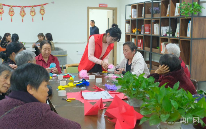 社区养老服务站里的志愿者和老人们一起做手工（央广网发  黄银雪  摄）