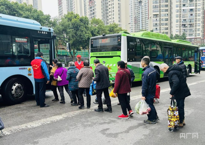 两江公交志愿者在公交站现场协调秩序（央广网发  陈永乐  摄）