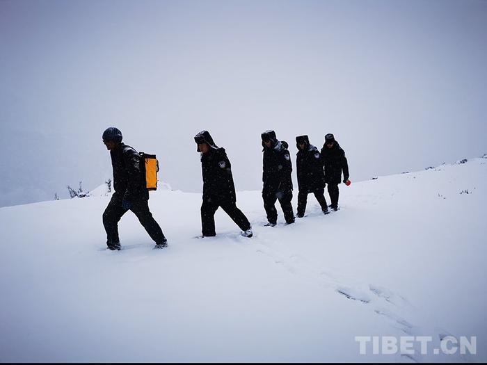 图为色边境派出所移民管理警察在雪地救援