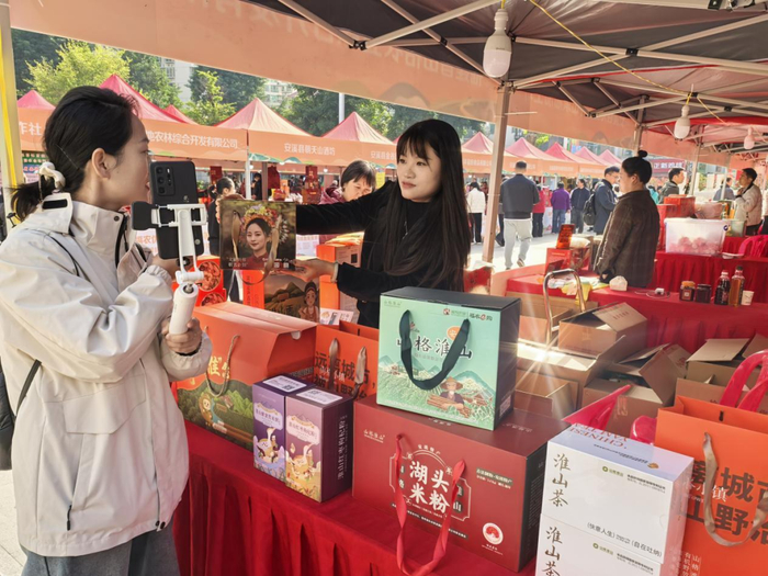 工作人员为主播展示淮山产品