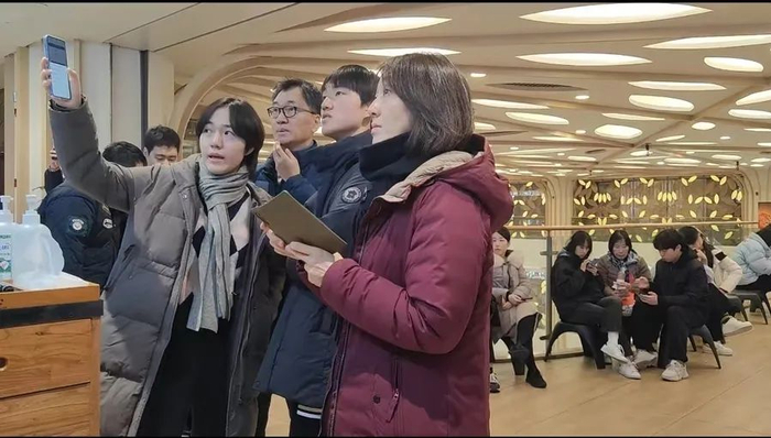 在南京路羊肉串店查看排队情况的韩国游客。    李宝花 摄