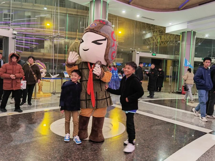 外国游客在上海马戏城与这里的吉祥物阿飞合影。     李宝花 摄