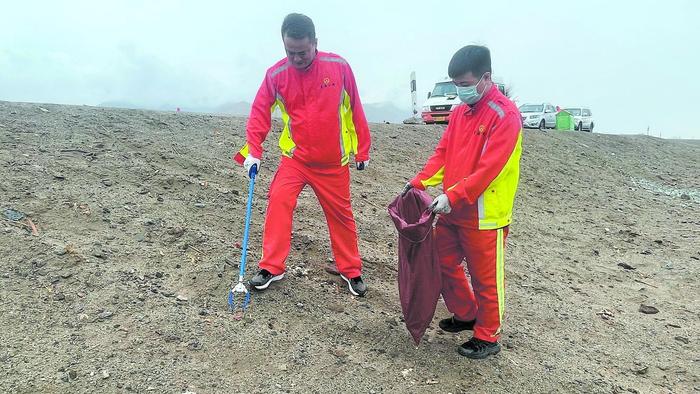 格东工区，正在道路沿线忙碌的养护工。马振东 摄