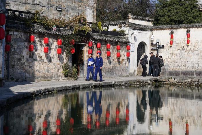   12月19日，舒建军（右）与同事谢晓强在黄山市宏村内进行日常巡逻。新华社记者 杜宇 摄