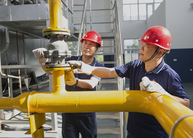 图为零陵卷烟厂动力车间锅炉班员工在查看天然气管路