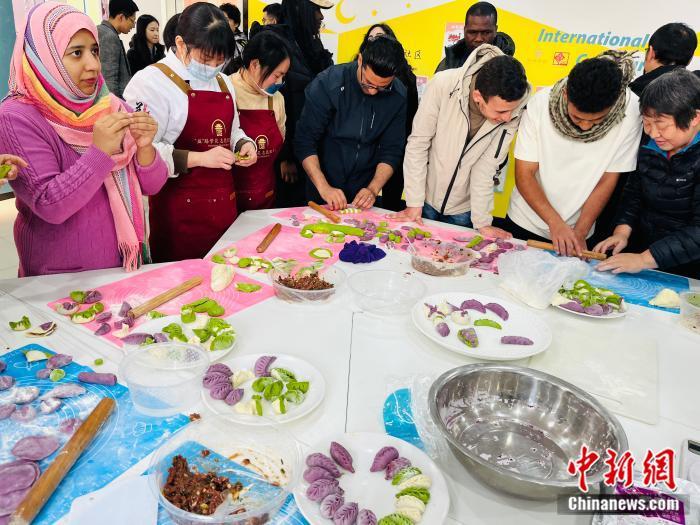   义乌鸡鸣山社区组织中外居民包饺子活动。(中新网 赵丽 摄)