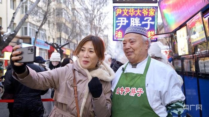 外地游客与尹文华合影（央广网见习记者 张瀚予 摄）