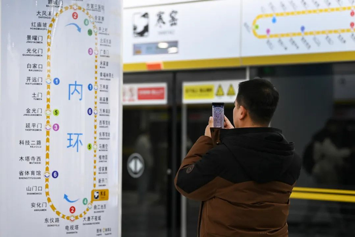 12月26日，一名乘客在西安地铁8号线寒窑站拍摄线路图。新华社记者 邹竞一 摄