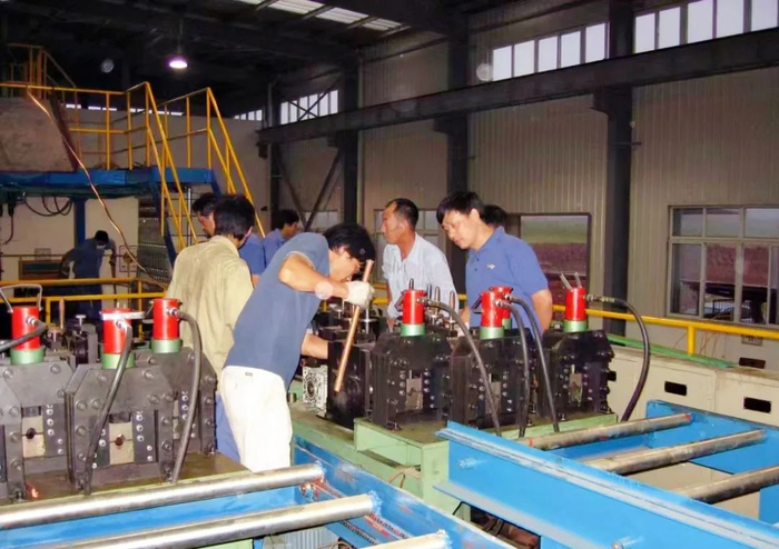 ▲ 图为扩建项目投产前夕技术人员正在对磷铜杆牵引校直系统进行调试。