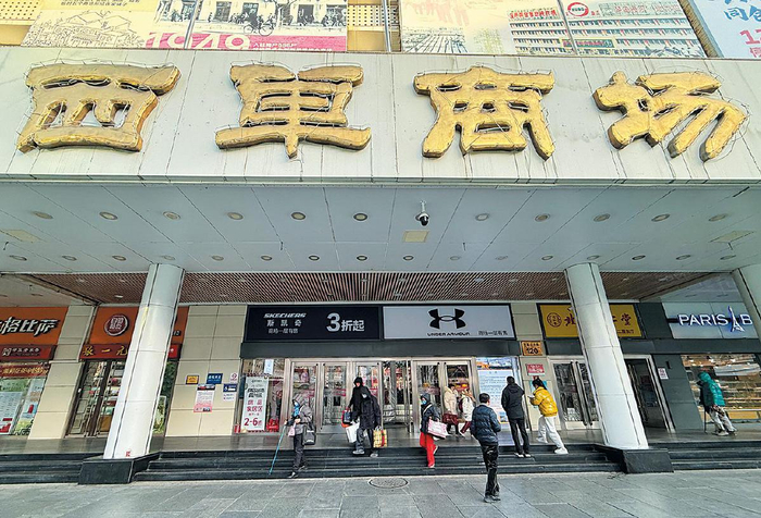 12月25日，市民选购商品后走出西单商场。 　新京报记者　王贵彬　摄