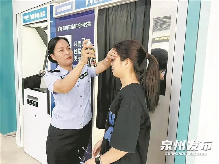 在自助拍照机前，民警协助办证群众整理头发。