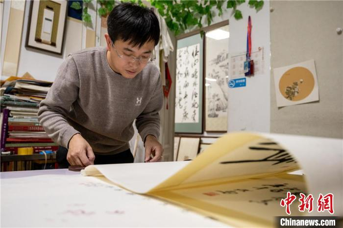 白彦斌正在手工装裱字画。韦亮 摄