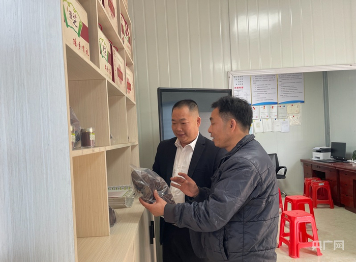 黄佩明和村民交流灵芝产业发展情况（央广网记者  张顺鹏  摄）