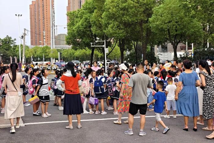 放学时间，学校门口人群聚集。图源：视觉中国