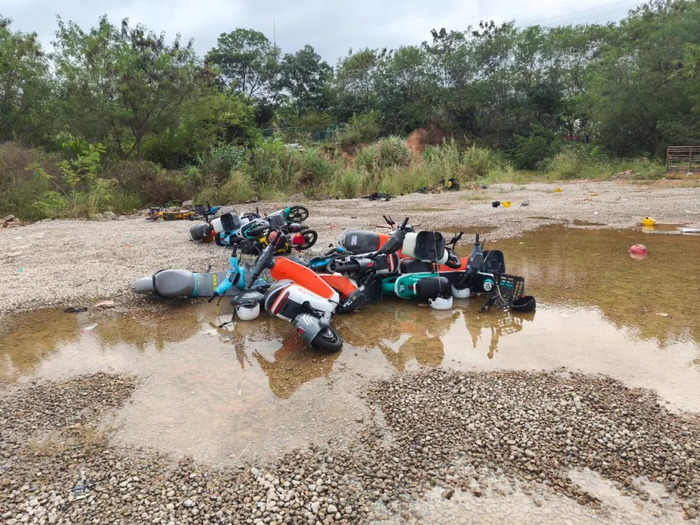 雨天过后，被扣押的共享电单车浸泡在水中 图片来源：每经记者 陈浩 摄