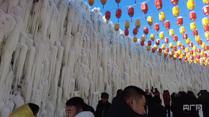 游客纷纷在冰瀑下打卡留念（央广网记者 舒震 摄）