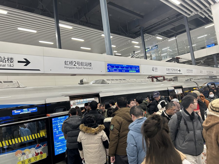 在市域机场线虹桥2号航站楼站，乘客正在上下车。