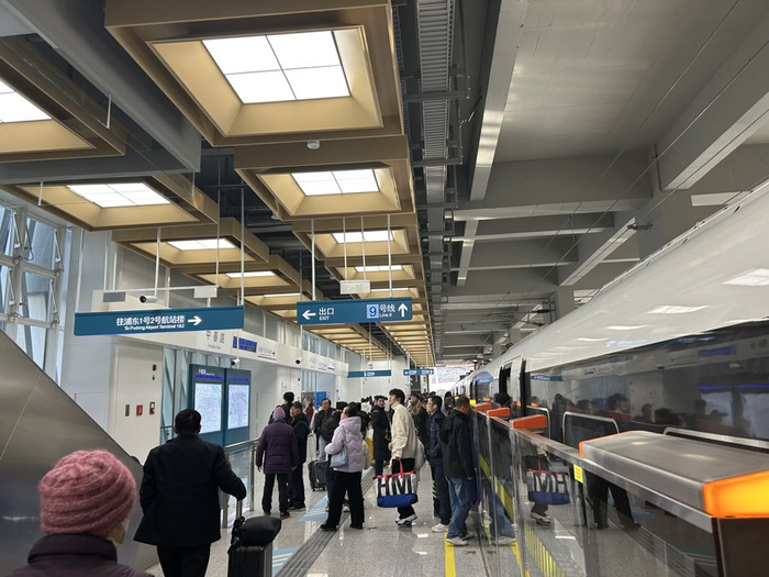 在市域机场线中春路站，乘客正在上下车。