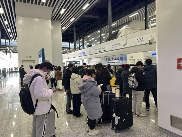 在市域机场线虹桥2号航站楼站，不少市民在屏蔽门前排起队，还有新的乘客陆续加入。
