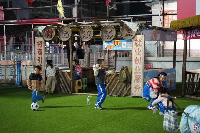 村超球场的角落里，爱好足球的小朋友正在游戏。 王倩 摄