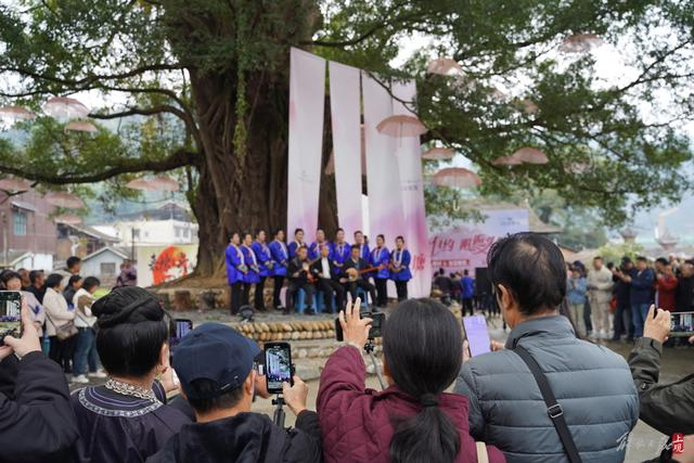 在头塘村的村集活动上，村民和游客的手机都对准了榕树下的表演者。 王倩 摄