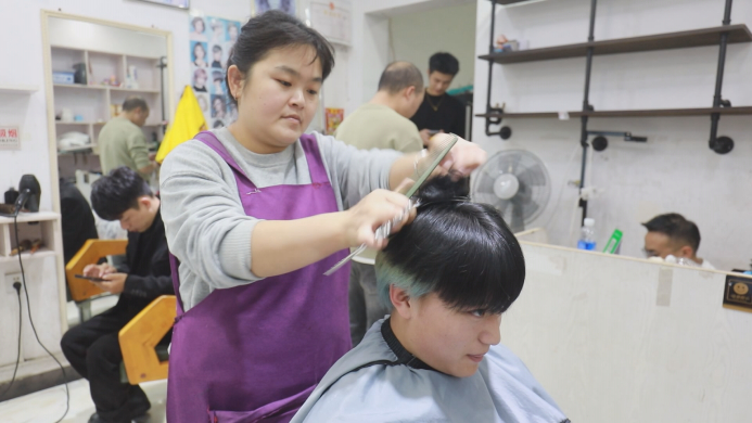 　　晓华在给顾客理发