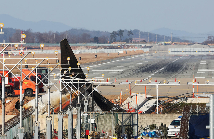 ▲12月30日，在务安国际机场的跑道上，留下了机身着陆时发生碰撞并爆炸的济州航空客机的痕迹和残骸。图据视觉中国