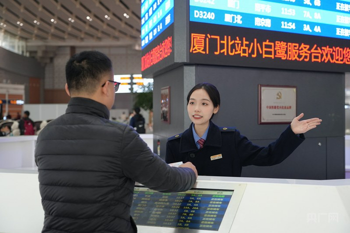 工作人员为旅客指引检票口（央广网发  姜媛  摄）