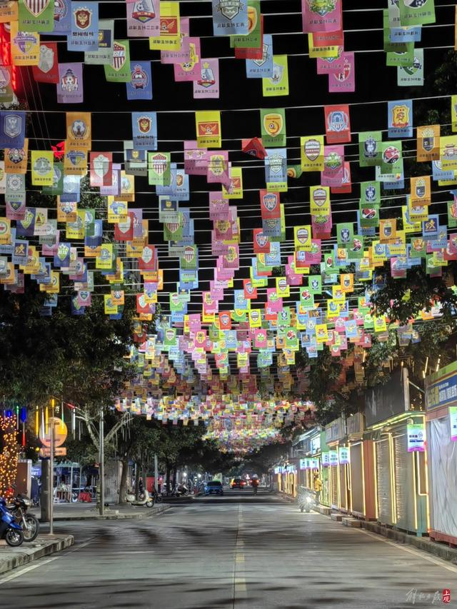 村超球场外挂起的印有各支球队logo的彩旗。张凌云摄