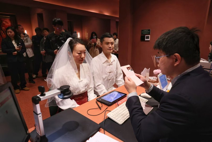 工作人员核对吴先生与爱人的领证材料。 文汇报记者 叶辰亮摄
