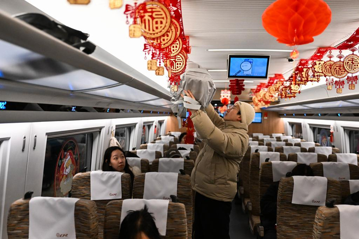 　　2024年12月31日，一位乘客在呼和浩特东站开往太原南站的G4798次列车上摆放行李。新华社记者 李志鹏 摄