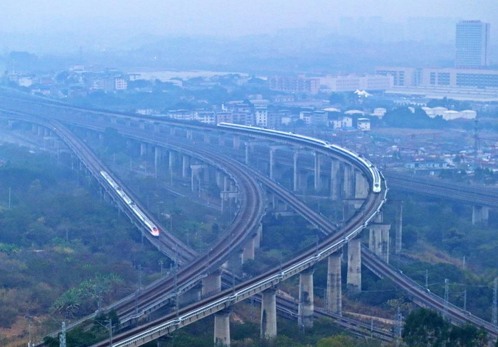　　列车（右）行驶在南珠高铁南玉段屯里大桥上（2024年12月30日摄，无人机照片）。新华社记者 周华 摄