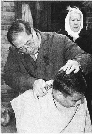 1997年，东城区安定门街道开通社区便民热线电话，为民解忧。图为志愿者上门为行动不便的残疾人理发。 张旭摄