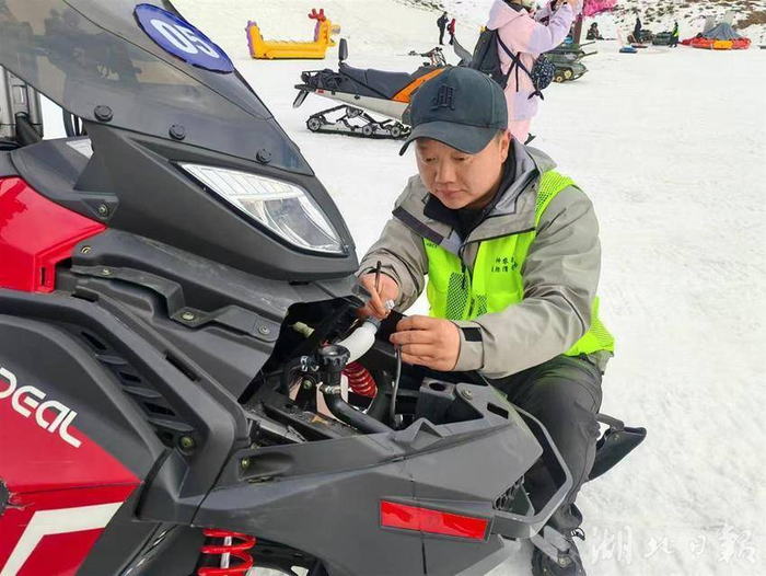 工作人员正在检修雪地摩托。 （通讯员 刘畅 摄）
