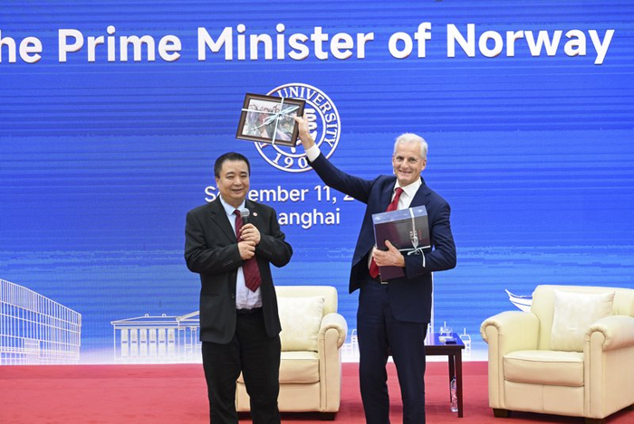 图为去年挪威首相斯特勒（右）在复旦大学演讲后，收到两份特殊礼物。本报记者张驰摄