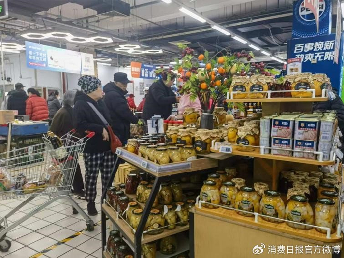 图为消费者在超市选购罐头。