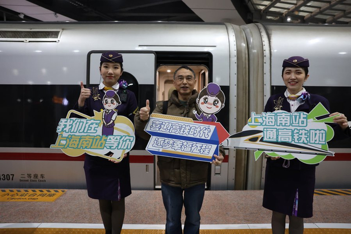 旅客与上海南站首趟高铁合影。