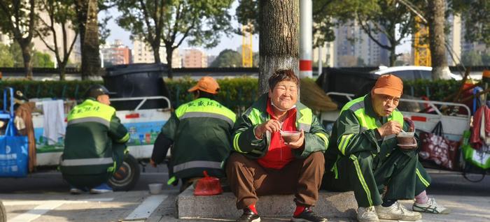 在柳市镇政府广场附近，环卫工人喝上热腾腾的腊八粥。张皓 摄