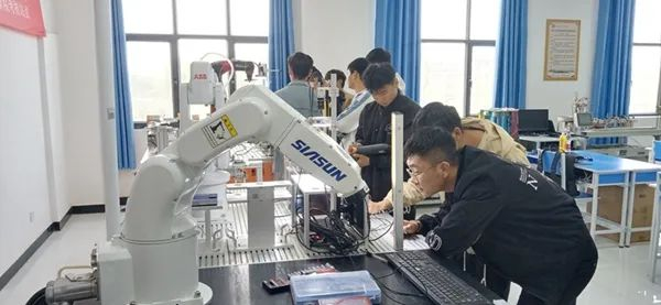 阿克苏职业技术学院实训基地内，机电工程学院工业机器人兴趣小组学生在观摩学习（2023年5月8日摄）。