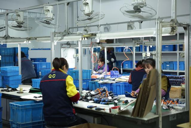 图说：生产车间里，工人正在忙碌。