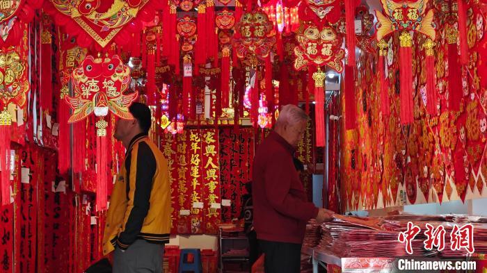 1月8日，临近春节，海口百年骑楼老街年味十足。图为民众在选购贺年装饰等年货。沈南 摄