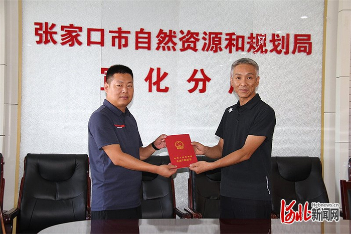 2024年8月7日，张家口兆铭汽车科技有限公司总经理韩志刚（左）拿到了不动产权证书。李蕾摄