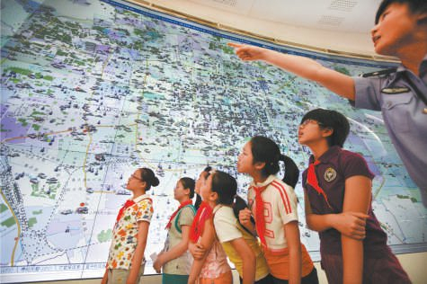 2010年，来自东交民巷小学的35名师生参观指挥中心110报警台监控大屏幕。 饶强摄