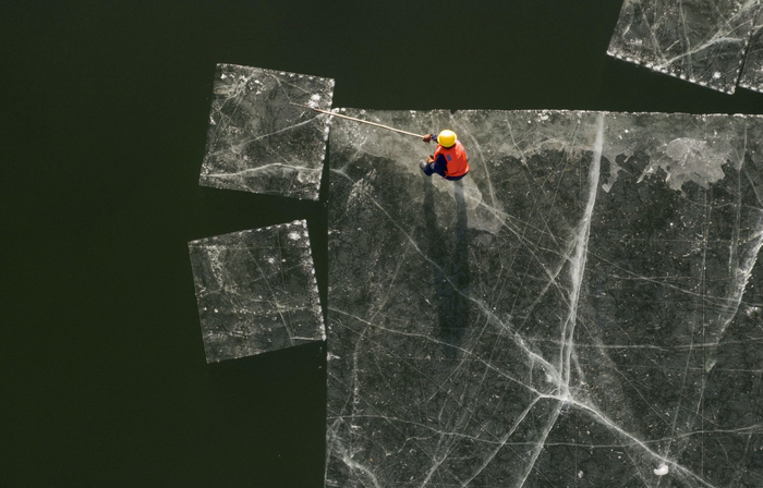 取冰师傅将切割好的整块冰用钩子移至吊装区域。