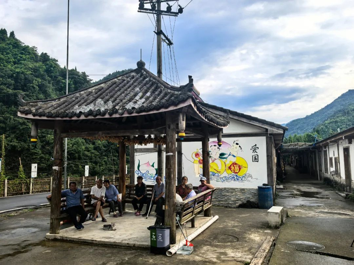 五星村村民坐在村中的凉亭里纳凉。