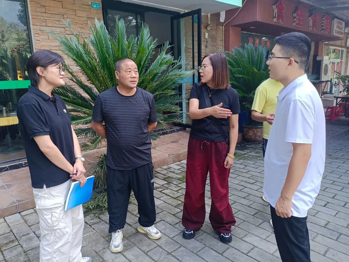 图为余绍容代表（左三）在走访当地群众。