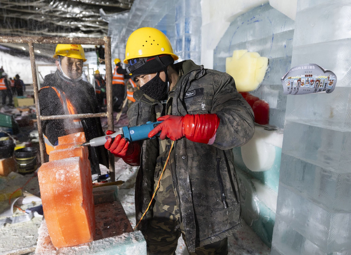 工作人员对彩冰进行雕刻。